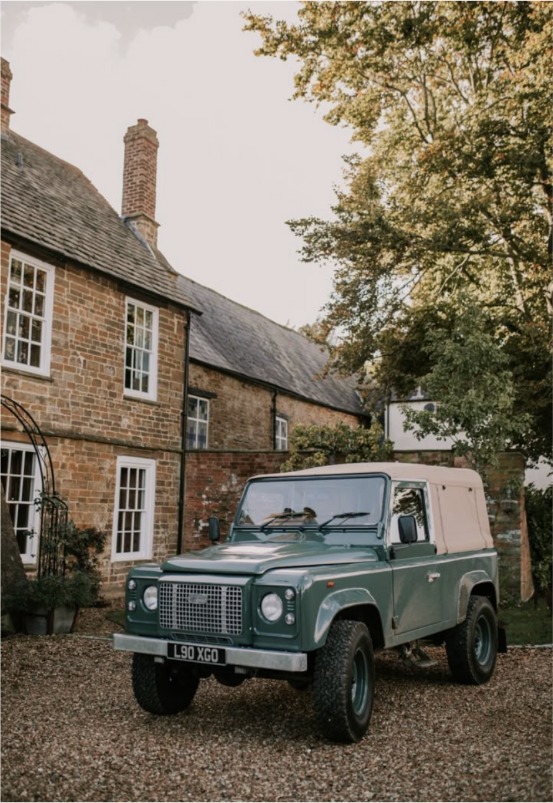 Stone country cottage with a green Land Rover parked outside